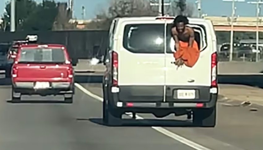 Video shows inmate hanging from back window of prison van while being transported